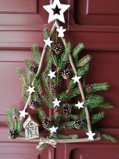 a christmas tree made out of branches with white stars and pine cones hanging from it