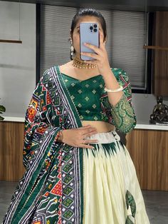 Elevate your ethnic wear collection with this beautiful off-white & green patola printed silk traditional lehenga choli. Crafted from high-quality dola silk material, this stunning ensemble features intricate patola and paithni printed work along with foil work (crush work) that adds a touch of elegance and sophistication. The off-white lehenga is paired with a green color dola silk choli and a matching dupatta, making it a perfect choice for weddings, festivals, or any special occasion.
Thi Traditional Ikat Print Choli For Festivals, White Ikat Print Dupatta, Traditional Ikat Print Choli For Navratri, Traditional Green Lehenga With Bandhani Print, White Ikat Print Dupatta For Navratri, White Ikat Print Traditional Wear For Diwali, Green Traditional Wear With Ikat Print And Traditional Drape, Green Traditional Wear With Ikat Print Drape, Green Ikat Print Traditional Drape Wear