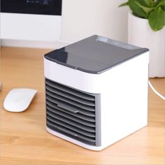 a white and gray computer tower sitting on top of a wooden desk