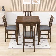 a dining room table with chairs and a rug on the floor