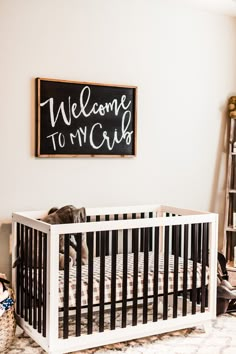 a baby's crib with a welcome to my girl sign on the wall