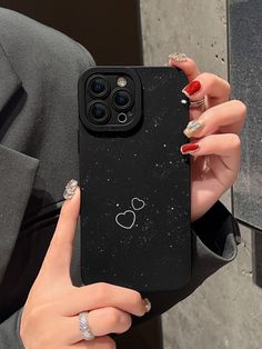 a woman holding up her phone case with mickey mouse on it