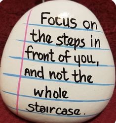 a rock with writing on it that says, focus on the steps in front of you and not the whole staircase