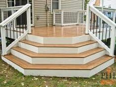 a wooden deck with white railing and handrails