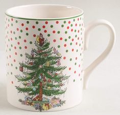 a coffee mug with a christmas tree painted on the front and sides, decorated with polka dots