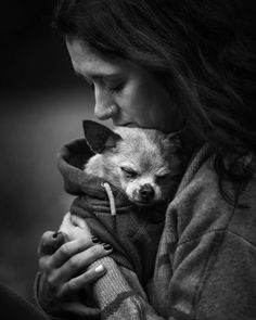 a woman holding a small dog in her arms