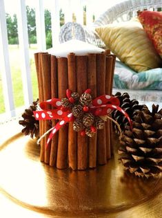 some cinnamon sticks are sitting on a table next to pine cones and a candle holder