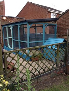 a blue chicken coop in the back yard