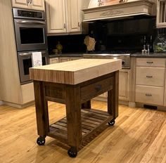 a kitchen island sitting in the middle of a wooden floor