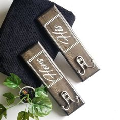 two wooden signs sitting next to each other on top of a black cloth covered table