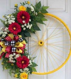 a bicycle wheel wreath with red and yellow flowers hanging on the front door to welcome guests