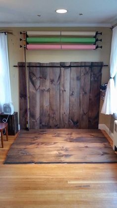 an empty room with wood floors and white curtains