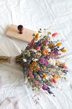 a bunch of dried flowers sitting on top of a white sheet