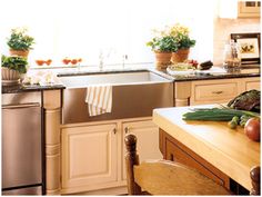 a kitchen filled with lots of counter top space and pots full of vegetables on the counters