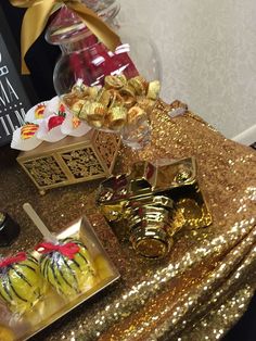 there are many desserts on the table with gold sequins and ribbons around them