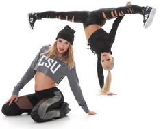 two young women are doing acrobatic tricks on the floor in front of a white background