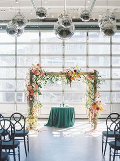 an outdoor ceremony setup with green table cloth and hanging disco ball chandelier over it