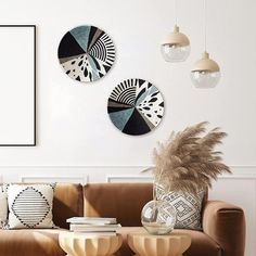 a living room with two couches and three circular mirrors on the wall above them