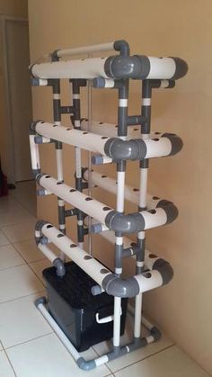 there is a rack made out of pipes on the floor in front of a wall