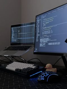 two computer monitors sitting next to each other on top of a black desk with a keyboard and mouse