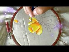 a person is stitching something on a piece of fabric in a hoop with scissors