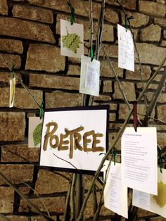 a tree that has been decorated with paper and some writing on it, next to a brick wall