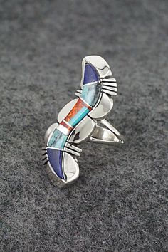 This turquoise, lapis, opalite and sterling silver inlay ring was made by Navajo silversmith James Manygoats. The back is stamped R.B. and .925.Size: 5.5Length: 1 1/2"Width: 1/2"Free shipping on all orders! We ship with USPS and always include tracking. All orders ship within a day of payment.Returns are accepted up to 30 days after you receive your order. Just send us a message. Our shop offers cash back or store credit. The item must be returned in the same condition. Southwestern Sterling Silver Opal Ring, Collectible Blue Inlay Rings, Unique Sterling Silver Opal Inlay Ring, Unique Sterling Silver Opal Ring With Inlay, Multi Stone, Native American Jewelry, Free Jewelry, Turquoise, Sterling Silver