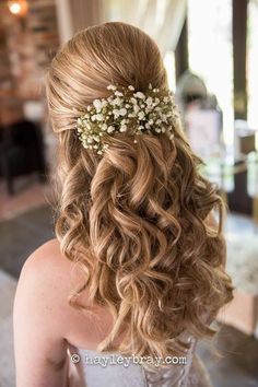 the back of a woman's head with flowers in her hair, wearing a wedding dress