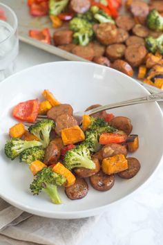 a white plate topped with sausage and broccoli