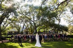 a bride and groom walking down the aisle at their wedding ceremony in front of a large group of people