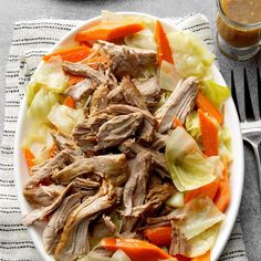 a white plate topped with meat and veggies next to a glass of orange juice