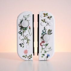 two white switch plates with flowers painted on them, one is facing the opposite direction