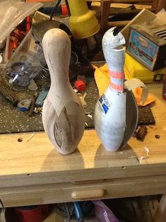 two wooden bowling pins sitting on top of a table next to other items and tools