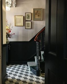 an entry way with stairs and pictures on the wall above it, along with a chandelier