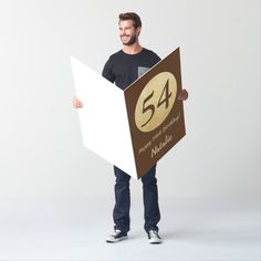 a man is holding a cardboard sign with the number 34 on it