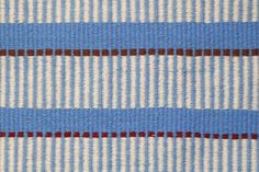 the blue and white striped fabric is very close to it's surface, with small red dots