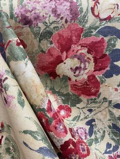 an upholstered floral print fabric with red, pink and blue flowers on it