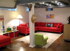 a living room filled with red couches and green chairs next to a white table