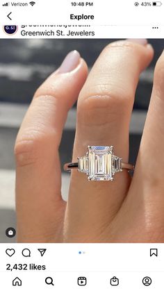 a woman's engagement ring with an emerald cut diamond in the center and side stones