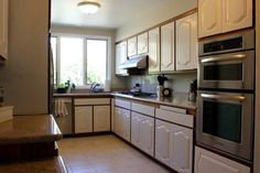 a kitchen with white cabinets and stainless steel appliances