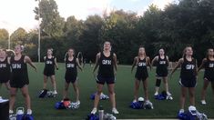 a group of cheerleaders standing on top of blue and white pom poms