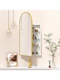 a bathroom vanity with a mirror and lights on the wall next to a potted plant