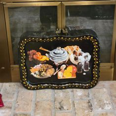 a black and gold tray with food on it sitting in front of a glass door