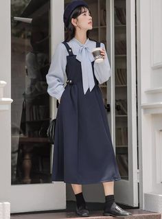 Preppy twofer midi dress with a faux layered look. Features tie neck blouse with long sleeves, a cami pinafore bodice with side pockets and embellished with golden buttons. Concealed side zipper closure. S: 33" chest, 26" waist, 44" lengthM: 34.5" chest, 27.5" waist, 44" lengthL: 36" chest, 29" waist, 44.5" lengthXL: 37.5" chest, 30.5" waist, 44.5" length Midi Dress Navy, Blouse With Long Sleeves, Tie Neck Blouse, Navy Midi Dress, Overall Dress, Layered Look, Sweater Blouse, Tie Neck, Cardigan Jacket