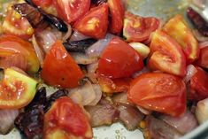 tomatoes and other vegetables are mixed together in a bowl