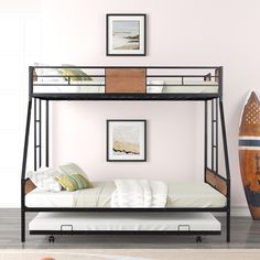 a bunk bed sitting next to a surfboard on top of a hard wood floor