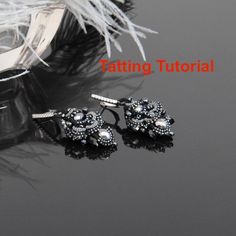 two pairs of earrings sitting on top of a table