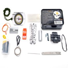 the contents of a survival kit laid out on a white table with scissors and other items