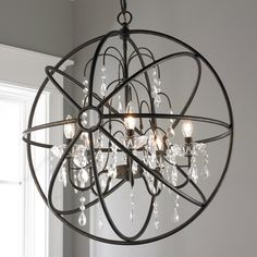 a chandelier hanging from the ceiling in a room with white walls and windows