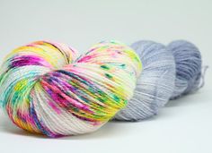 three skeins of multicolored yarn on a white background